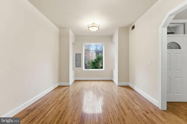 a view of a room with wooden floor and a ceiling fan