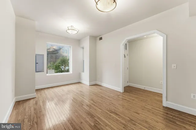 a view of an empty room with wooden floor