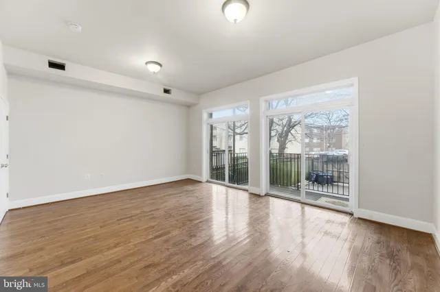 a kitchen with stainless steel appliances granite countertop a stove top oven a sink and dishwasher a microwave oven with wooden floor