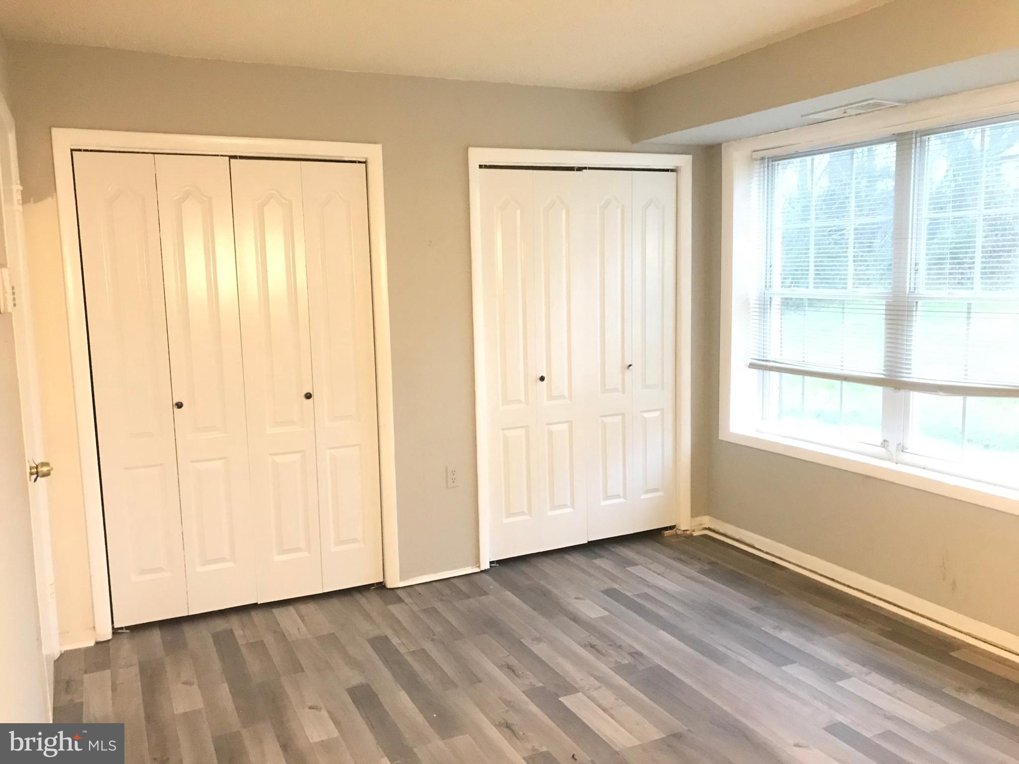 3807 Swann Road, Unit T1 Suitland, MD 20746 - Photo 5 of 8 a view of an empty room with wooden floor and a window