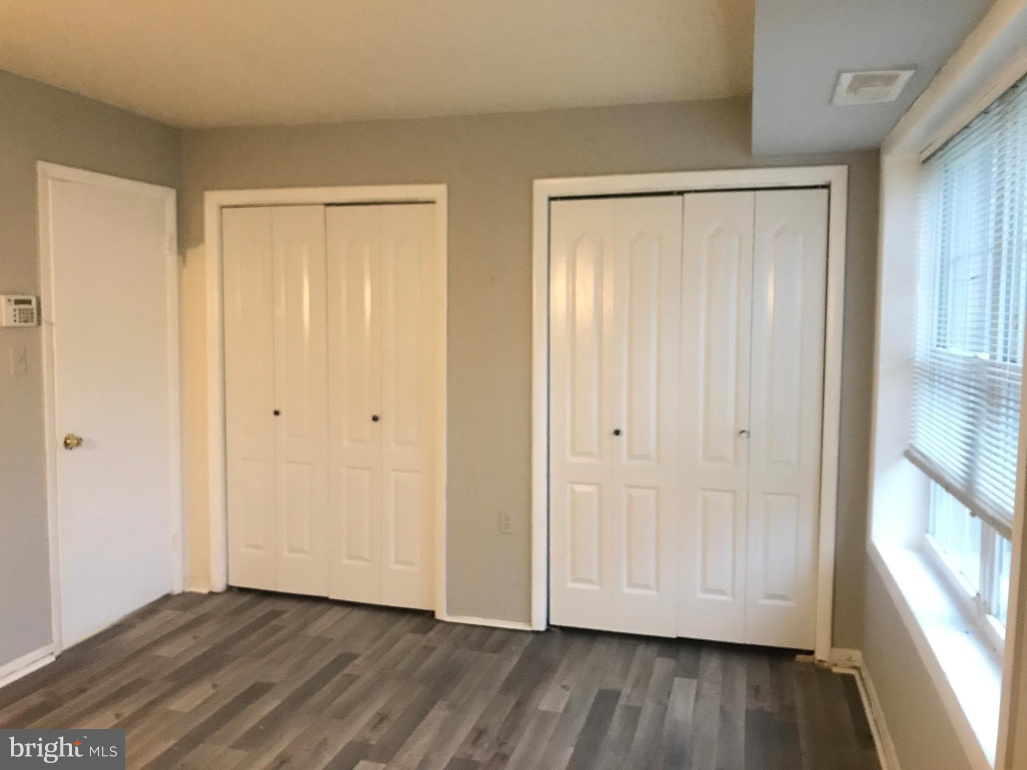 3807 Swann Road, Unit T1 Suitland, MD 20746 - Photo 7 of 8 a view of an empty room with wooden floor and a window