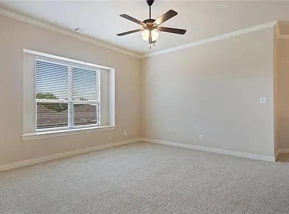 an empty room with a window and a fan