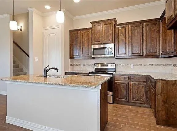 a kitchen with stainless steel appliances granite countertop a sink stove and cabinets