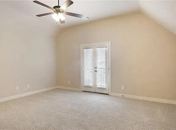 an empty room with a ceiling fan and a window