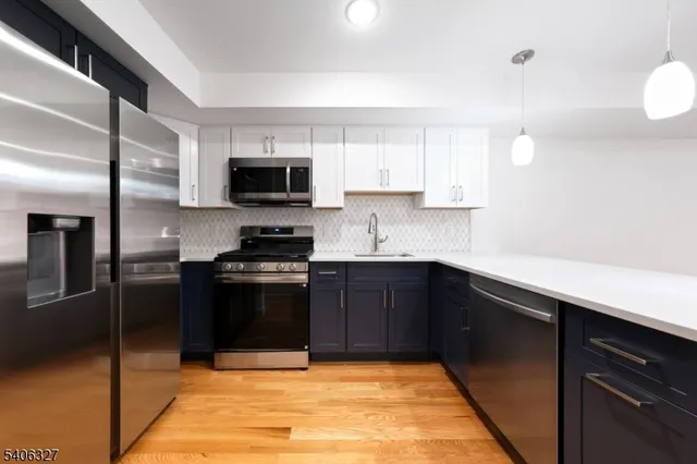 a kitchen with granite countertop a refrigerator and a sink