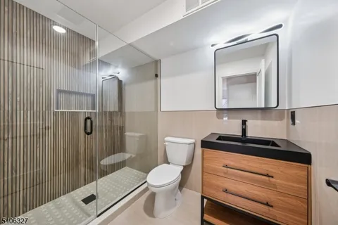 a bathroom with a toilet a sink and mirror