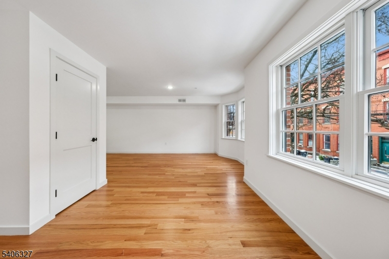 52 James Street, Unit 2 Newark, NJ 07102 - Photo 5 of 27 a view of an empty room with wooden floor and a window