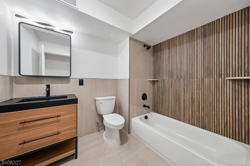 52 James Street, Unit 2 Newark, NJ 07102 - Photo 9 of 27 a bathroom with a toilet a sink a mirror and bathtub