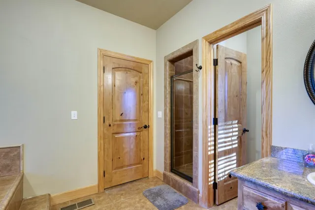 a bathroom with a glass shower door and mirror