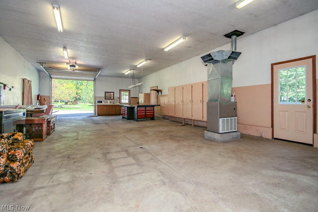6475 Taylor Road Painesville, OH 44077 - Photo 17 of 23 1 of 2 out building ifeaturing a concrete floor, overhead fluorescent lighting, and a roll-up door