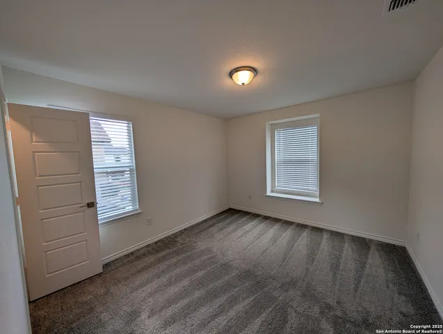 an empty room with closet and windows