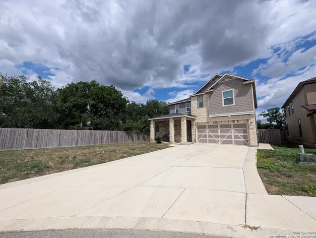 a view of backyard of house with wooden fence
