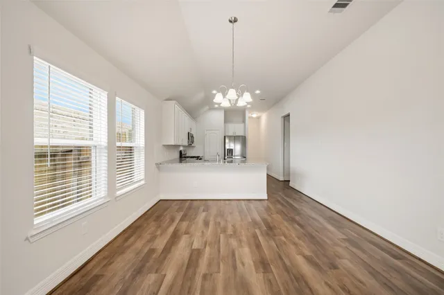 a view of a room with wooden floor and large windows