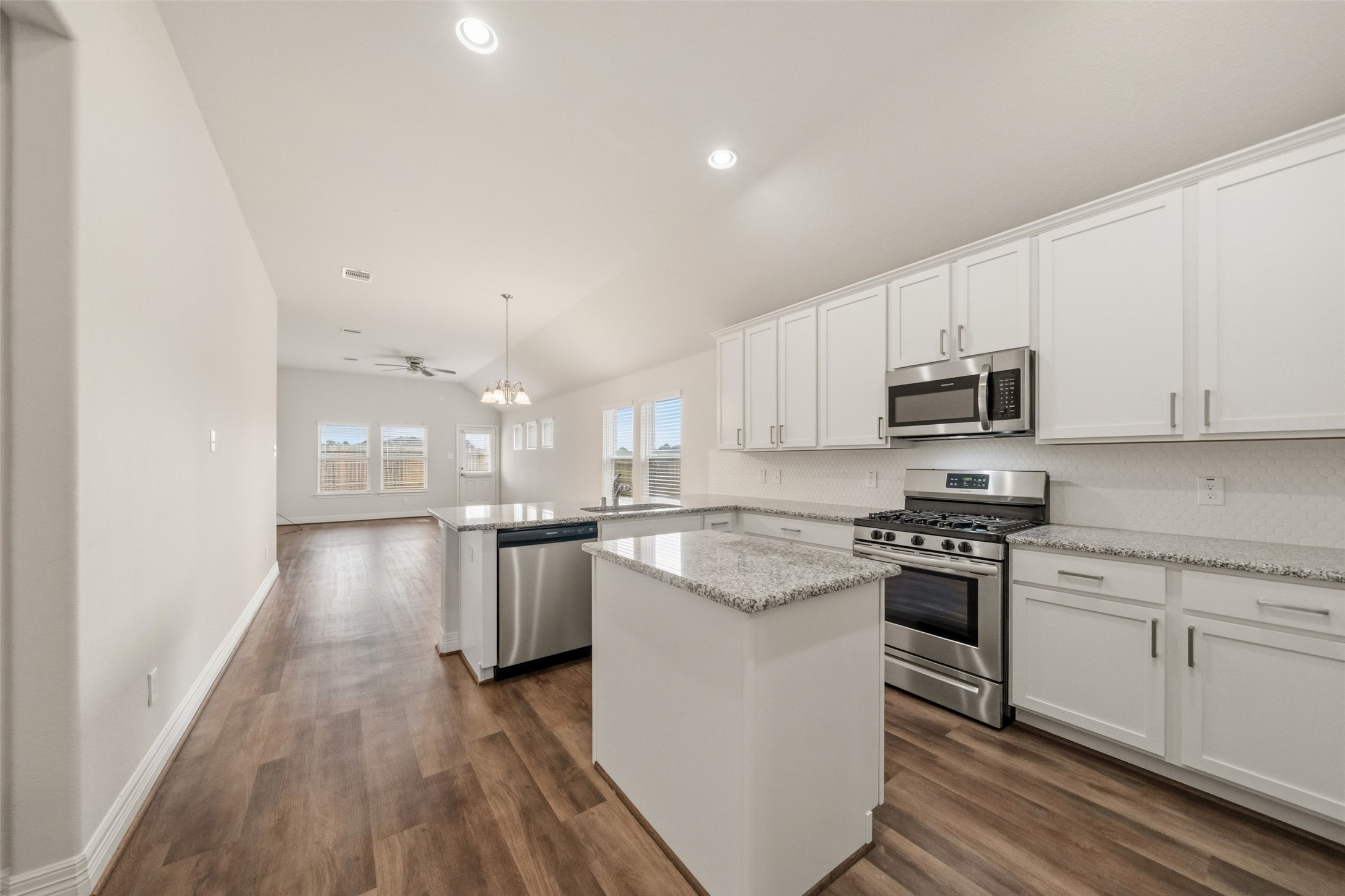 22642 Rosebush Hl Road Tomball, TX 77377 - Photo 2 of 27 a kitchen with stainless steel appliances granite countertop a stove top oven a sink dishwasher and a refrigerator with wooden floor