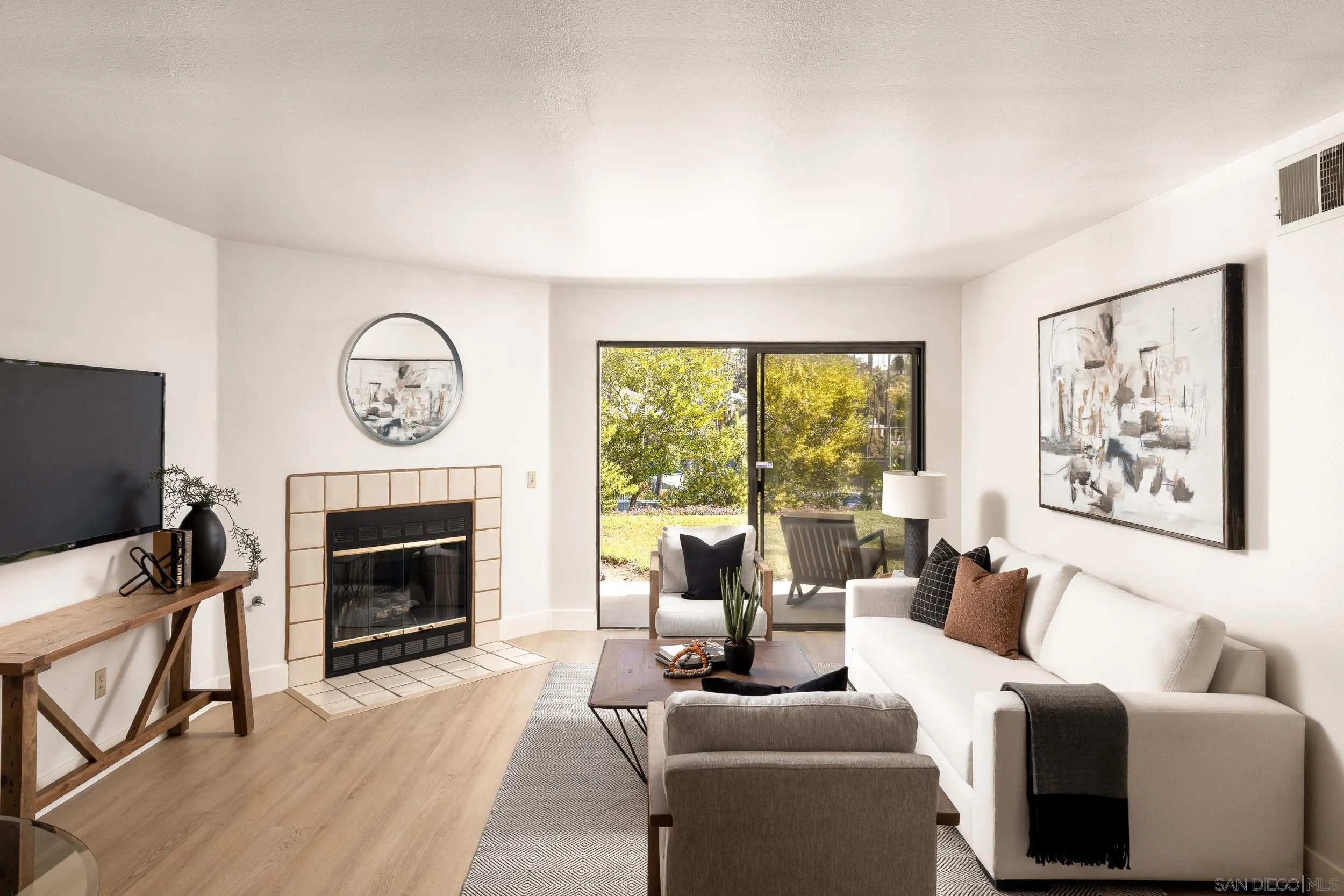 7306 Alta Vista Carlsbad, CA 92009 - Photo 3 of 22 a living room with furniture a large window and a fireplace