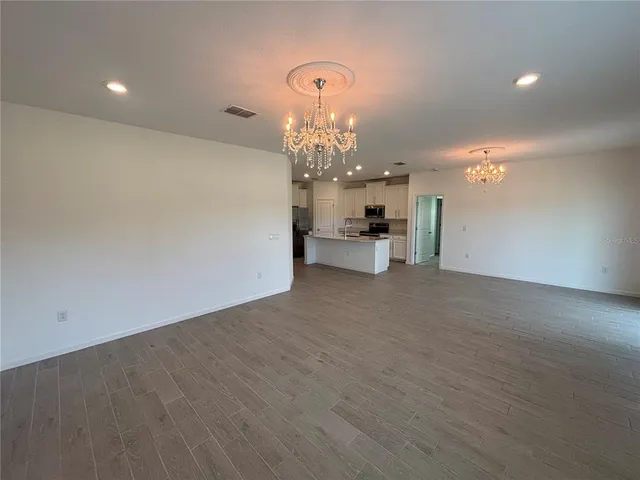 a view of a chandelier in big room and chandelier fan
