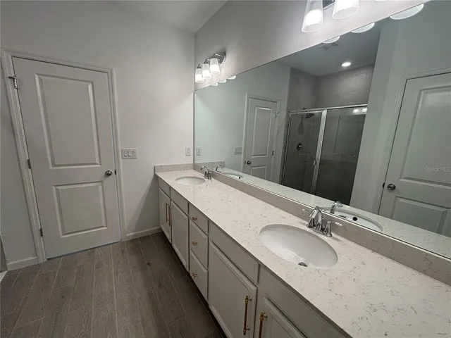 a bathroom with double vanity sink and a mirror