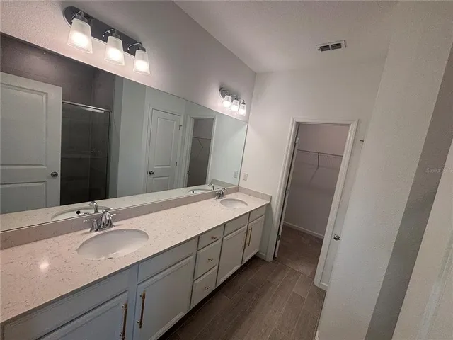 a bathroom with a double vanity sink and mirror