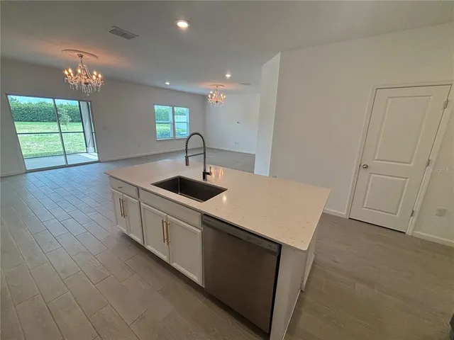 a kitchen with stainless steel appliances granite countertop a sink a stove a chimney a refrigerator and window