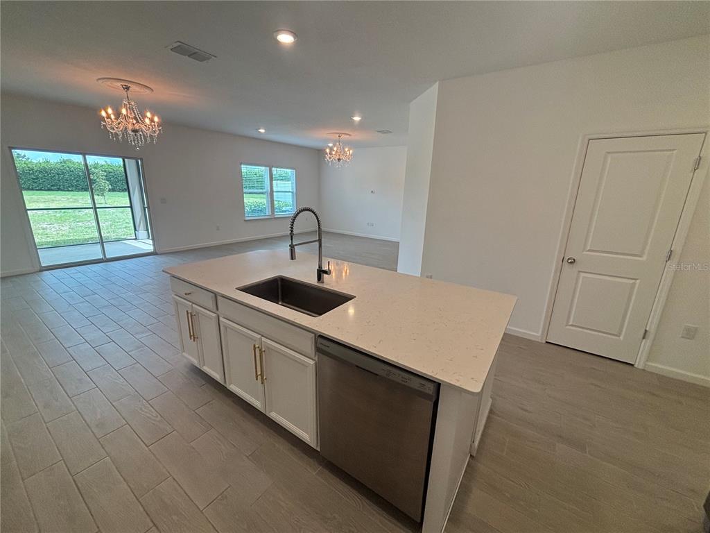 9145 Southwest 58th Circle Ocala, FL 34476 - Photo 4 of 37 a kitchen with stainless steel appliances granite countertop a sink a stove a chimney a refrigerator and window