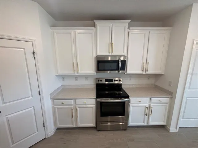 a kitchen with white cabinets and stainless steel appliances