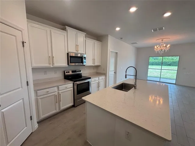 a kitchen with kitchen island granite countertop a sink stainless steel appliances and cabinets