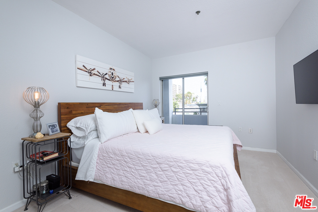 838 Pine Avenue, Unit 216 Long Beach, CA 90813 - Photo 13 of 35 a bedroom with a bed and a tv on table