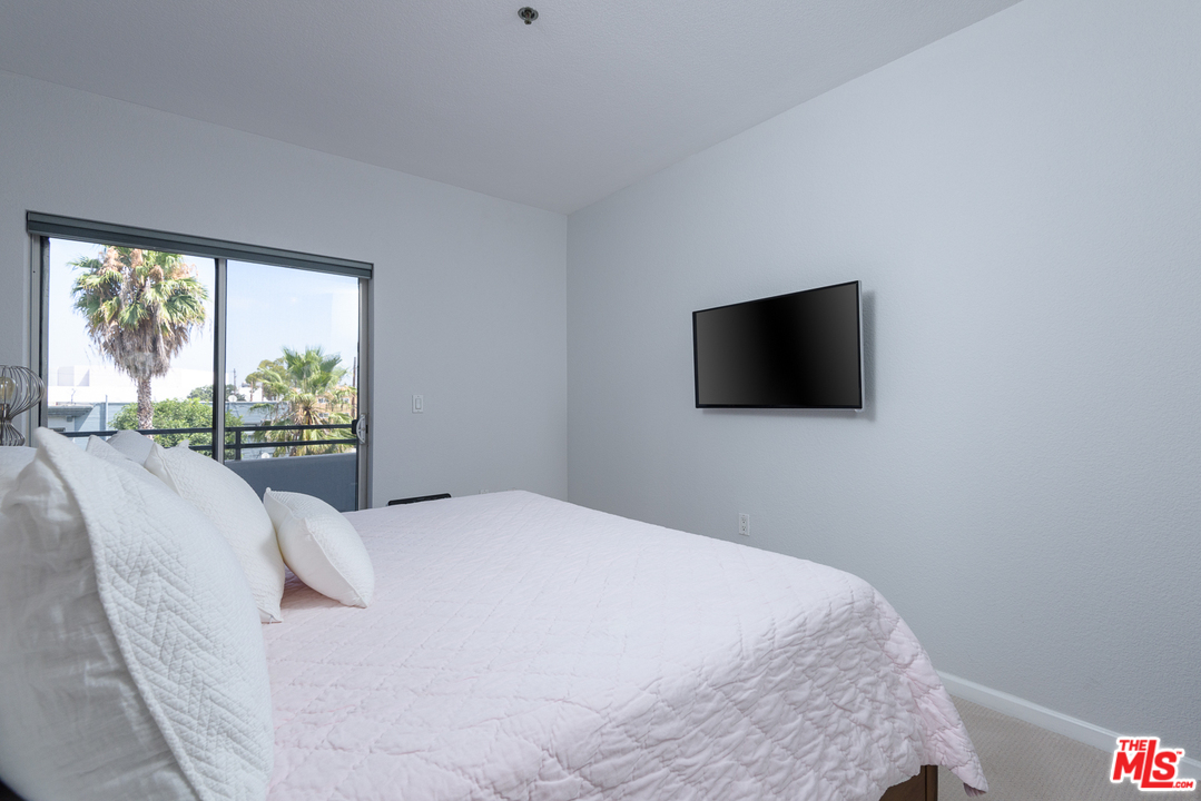 838 Pine Avenue, Unit 216 Long Beach, CA 90813 - Photo 14 of 35 a bedroom with a bed tv and a window