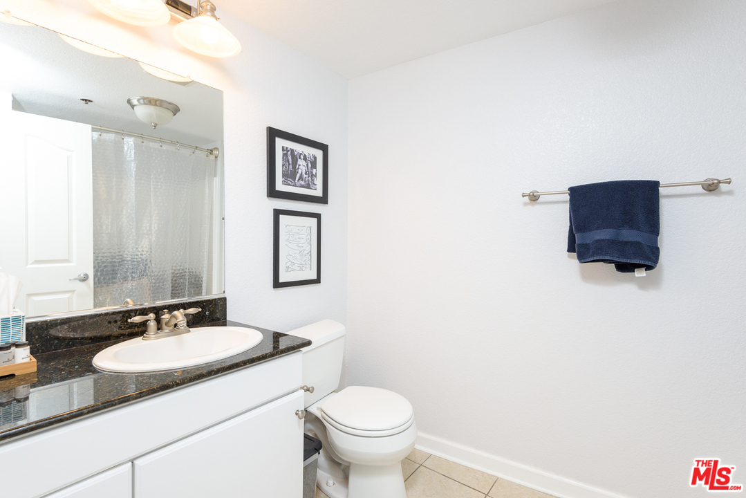 838 Pine Avenue, Unit 216 Long Beach, CA 90813 - Photo 20 of 35 a bathroom with a granite countertop sink toilet and mirror