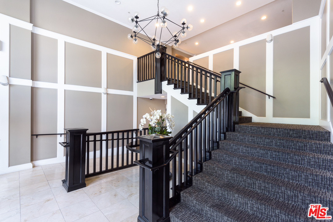 838 Pine Avenue, Unit 216 Long Beach, CA 90813 - Photo 24 of 35 a view of staircase with railing and a chandelier