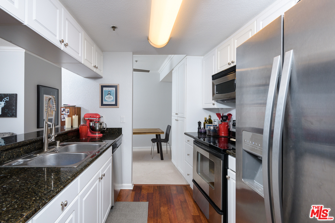 838 Pine Avenue, Unit 216 Long Beach, CA 90813 - Photo 10 of 35 a kitchen with stainless steel appliances granite countertop a sink refrigerator and cabinets