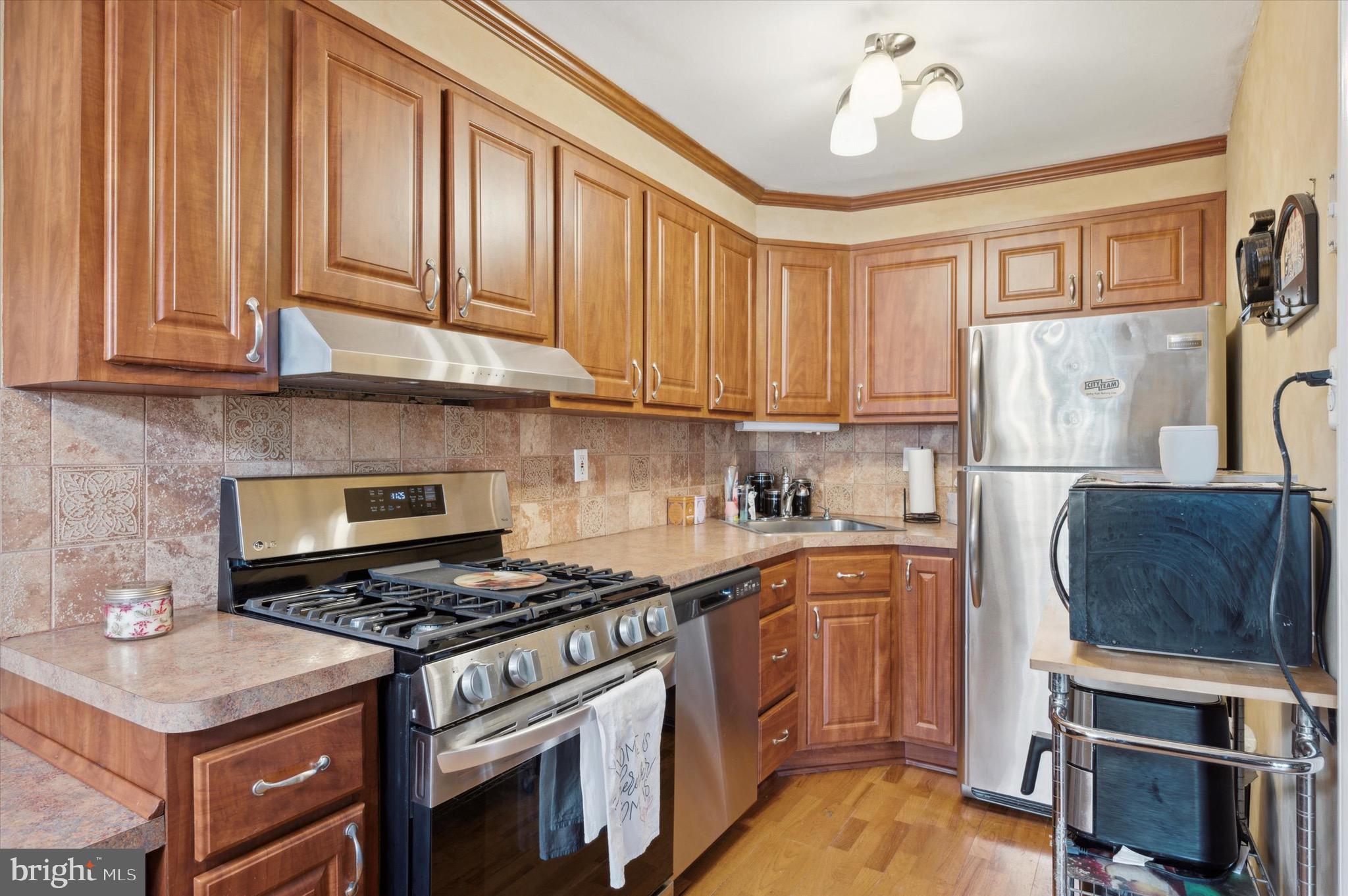 5229 North Springfield Road Clifton Heights, PA 19018 - Photo 9 of 25 a kitchen with granite countertop a stove a sink dishwasher and a refrigerator