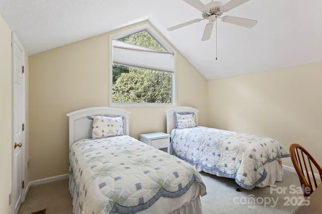 a bedroom with two beds and a chandelier