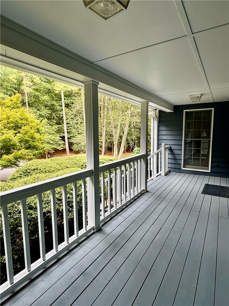 An inviting front porch offers serene views of lush surrounding foliage.