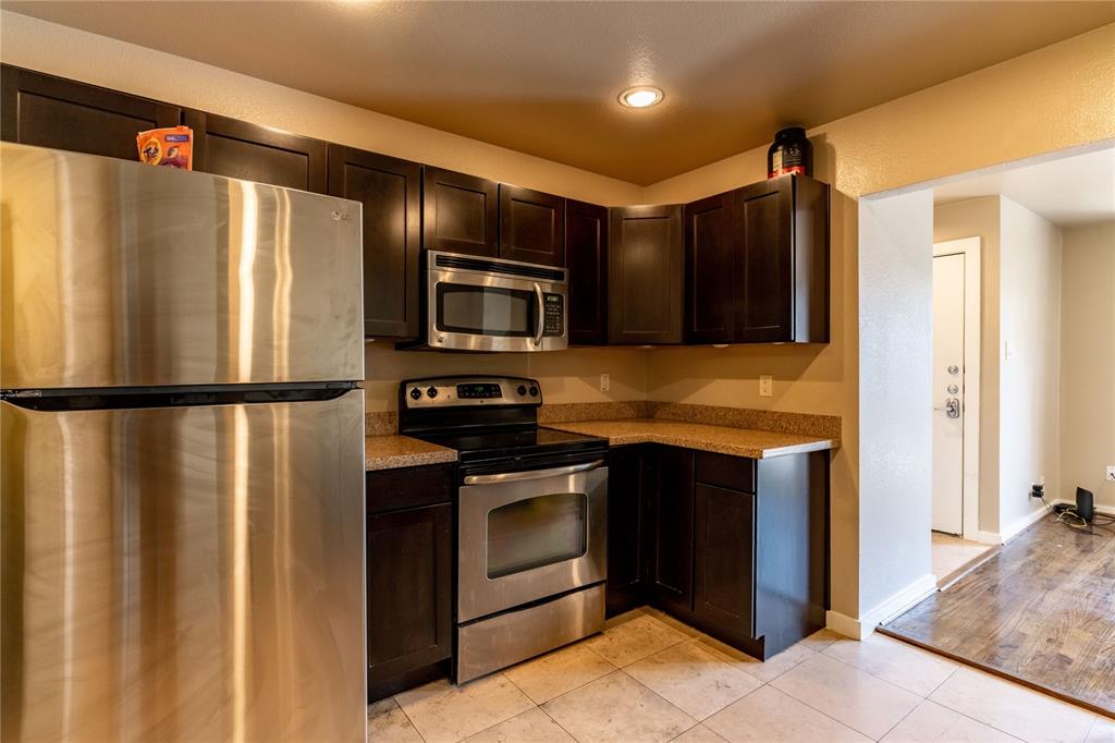 4777 Cedar Springs Road, Unit 8J Dallas, TX 75219 - Photo 14 of 30 a kitchen with stainless steel appliances granite countertop a refrigerator and a sink