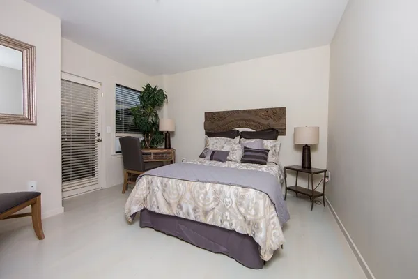 a bedroom with a bed a table and chair