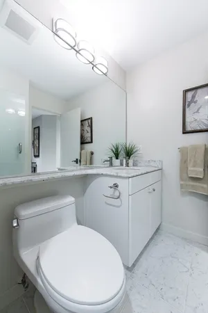 a bathroom with a toilet sink and mirror