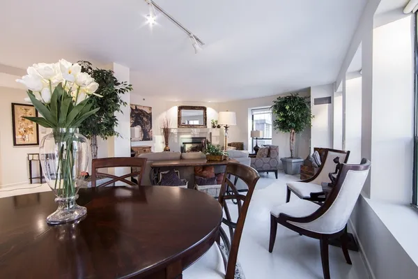 a living room with furniture kitchen view and a potted plant