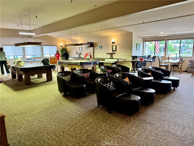 a room with furniture pool table and chairs