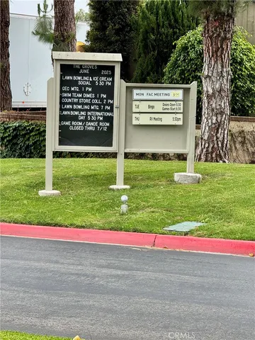a view of a sign board with buildings and street view