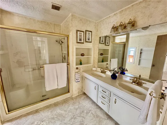 a spacious bathroom with double vanity and a mirror