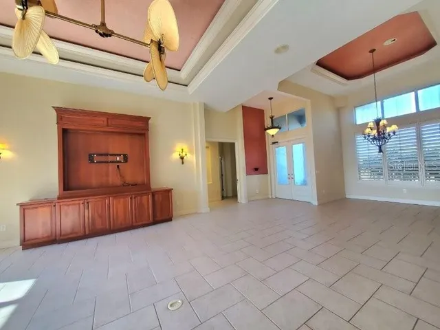 a view of a hallway with a chandelier fan and windows