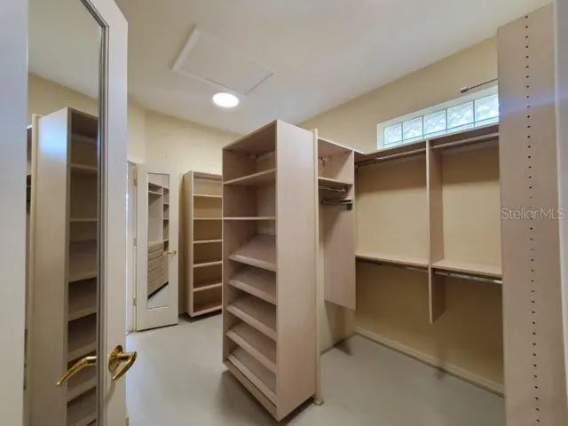 a view of walk in closet with empty racks