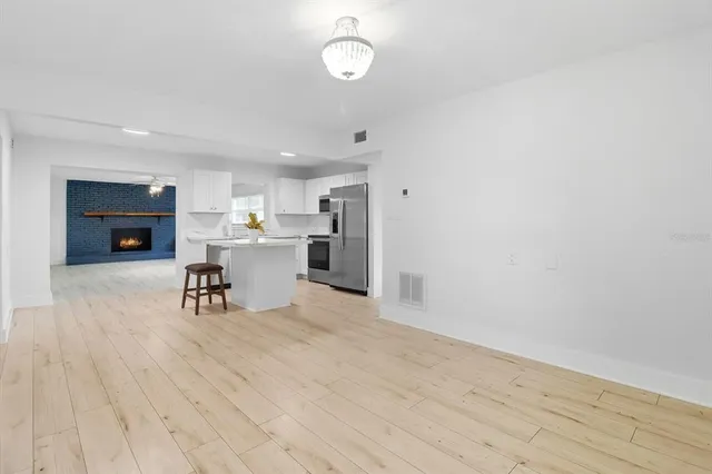 a view of a kitchen with wooden floor and electronic appliances