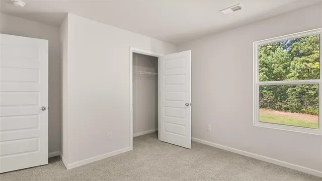 an empty room with windows and closet
