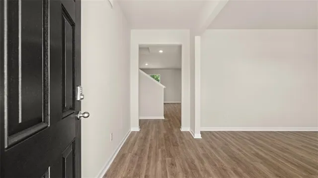 a view of a hallway with wooden floor and staircase