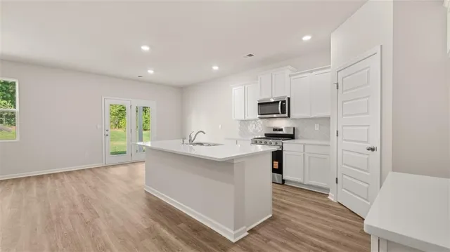 a kitchen with a sink a microwave a stove and cabinets
