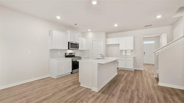 a kitchen with white cabinets stainless steel appliances and sink