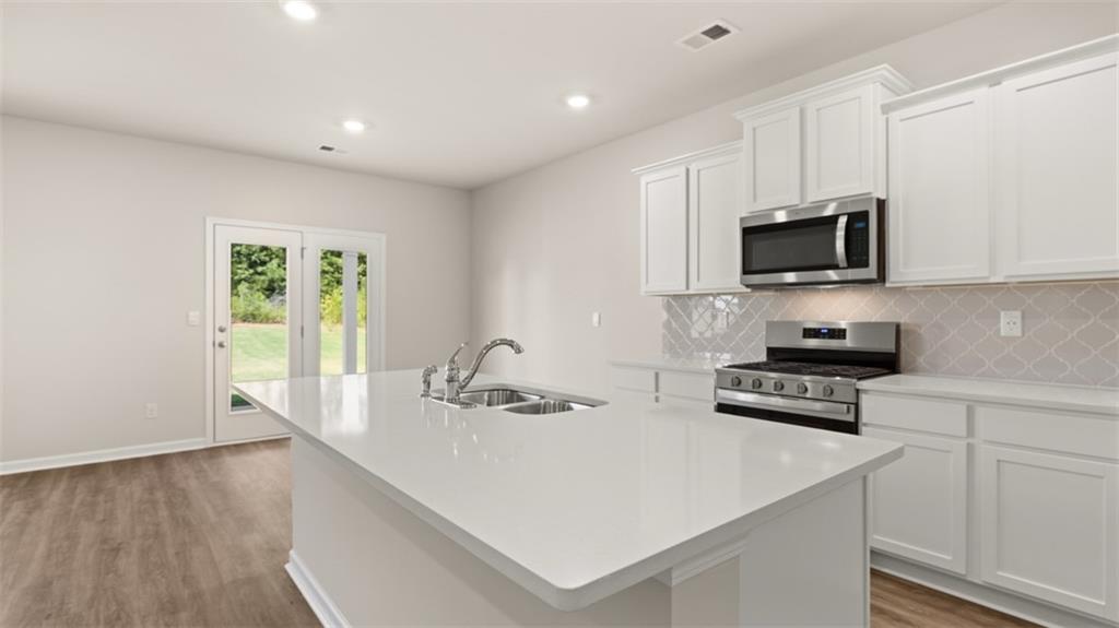 1898 Roxey Lane Winder, GA 30680 - Photo 7 of 21 a kitchen with stainless steel appliances a stove a sink a microwave a refrigerator and cabinets