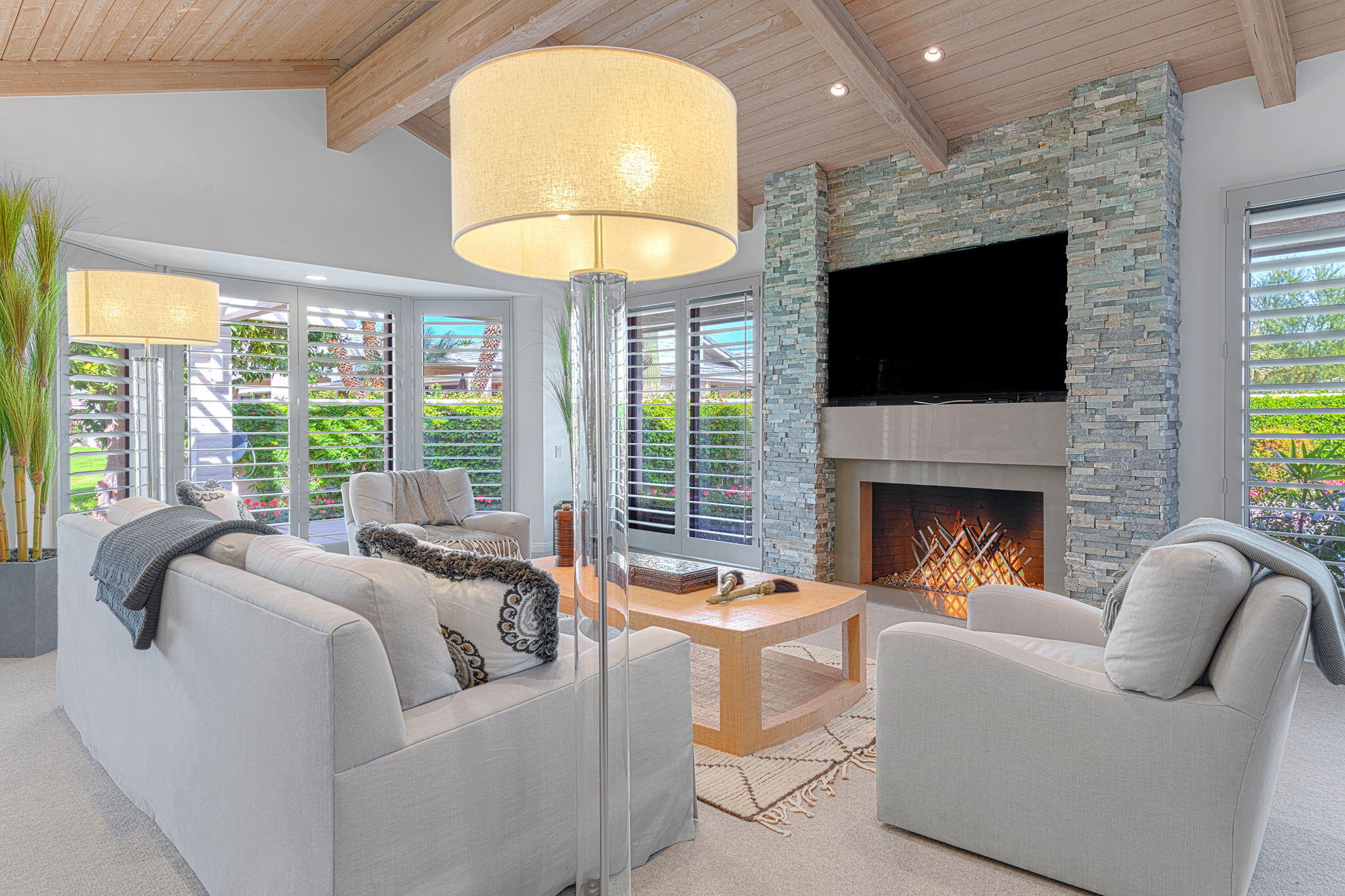 a living room with furniture a fireplace and a large window